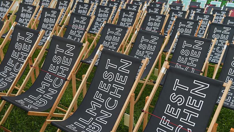 Liegestühle mit der Aufschrift Filmfest München stehen im Open Air Kino.