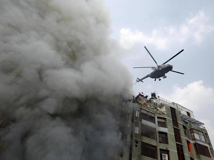 Ein Hubschrauber versucht, die im Gebäude festsitzenden Menschen in Sicherheit zu bringen.
