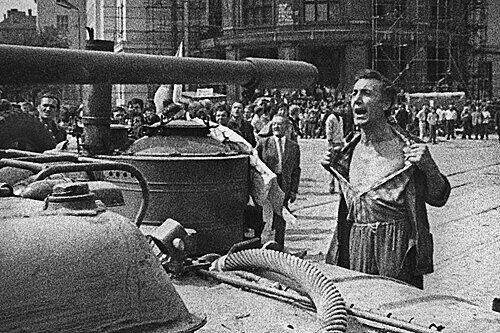 Ein Mann ruft mit entblößter Brust der Panzerbesatzung zu, sie sollen auf wehrlose Menschen schießen. Wenig später fallen hier Schüsse aus Maschinenpistolen der Besatzungstruppen, von denen dieser Mann tödlich getroffen wird.