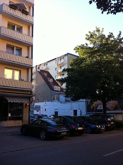 In einem Hinterhof ragt das spitze Gebäude in den Himmel.