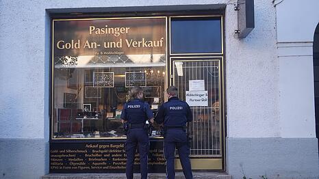 Zwei Polizisten vor dem Edelmetall-Gesch&auml;ft, das von zwei T&auml;tern &uuml;berfallen wurde.