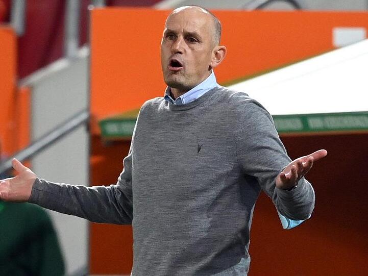 Heiko Herrlich, Trainer von Augsburg, hebt die Hände. Foto: Matthias Hangst/Getty Images Europe/Pool/dpa