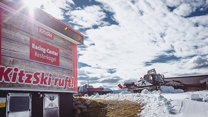 Bei strahlendem Sonnenschein ziehen sich weiße Kunstschnee-Teppiche durch die Kitzbüheler Alpen - befremdliche Bilder von der Saisoneröffnung.