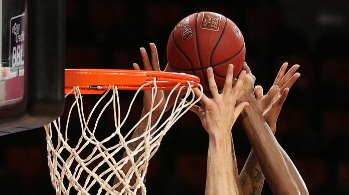 Basketballspieler gehen zum Rebound.
