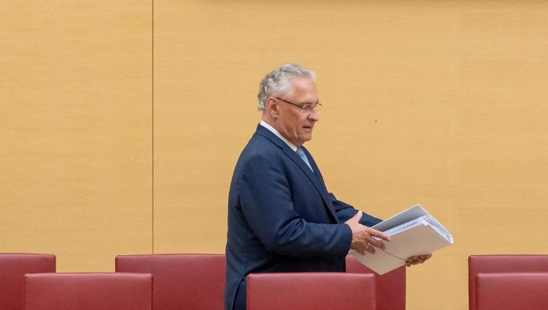 Joachim Herrmann (CSU), Innenminister von Bayern, geht während der Landtagssitzung an leeren Stühlen vorbei. Foto: Peter Kneffel/dpa