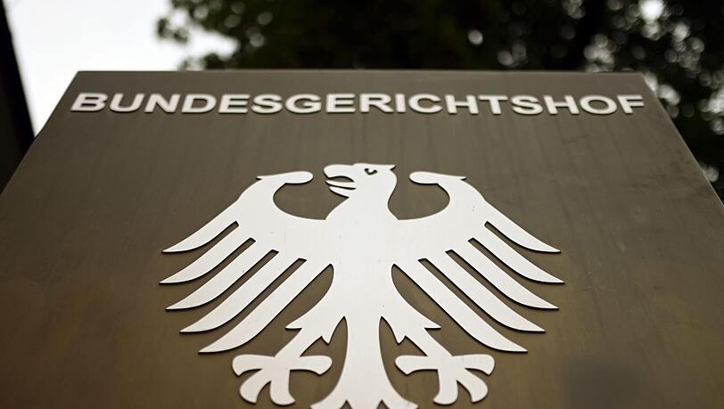 Ein Hinweisschild mit dem Bundesadler steht vor dem Bundesgerichtshof (BGH) in Karlsruhe.