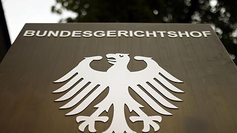 Ein Hinweisschild mit dem Bundesadler steht vor dem Bundesgerichtshof (BGH) in Karlsruhe.