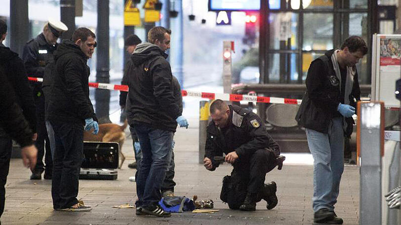 Sprengsatz an Gleis 1: Polizisten untersuchen am 10.12.2012 am Hauptbahnhof in Bonn die Reste einer Tasche.