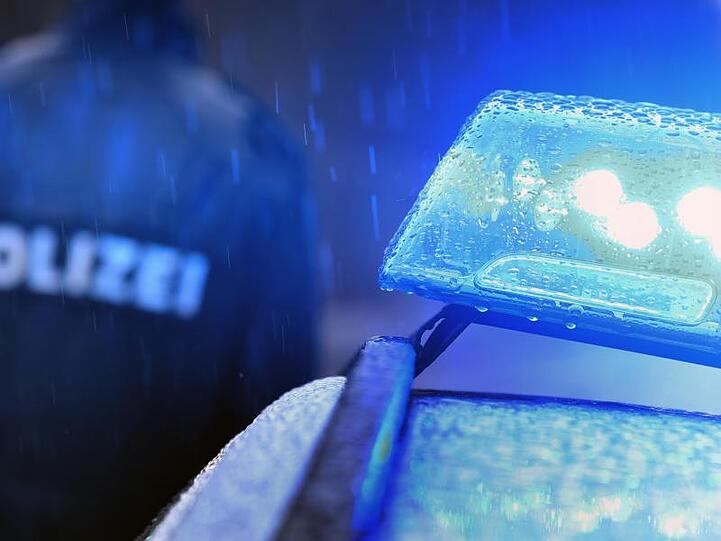 Ein Polizist steht vor einem Streifenwagen dessen Blaulicht aktiviert ist. Foto: Karl-Josef Hildenbrand/dpa/Archivbild