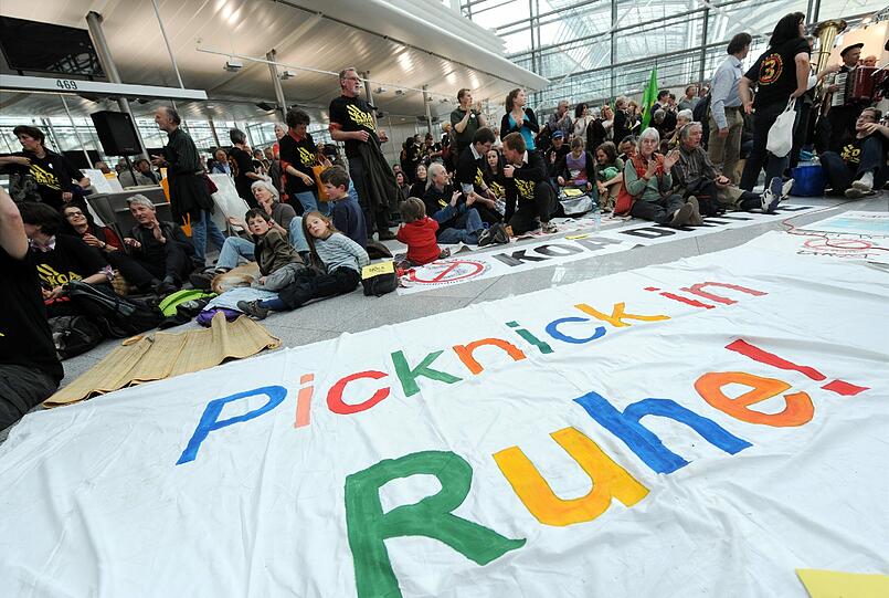 Gegen Fluglärm demonstrierende Demonstranten picknicken am Samstag (24.03.12) am Flughafen Franz-Josef-Strauss in einem Teil der Abflughalle des Terminal 2.