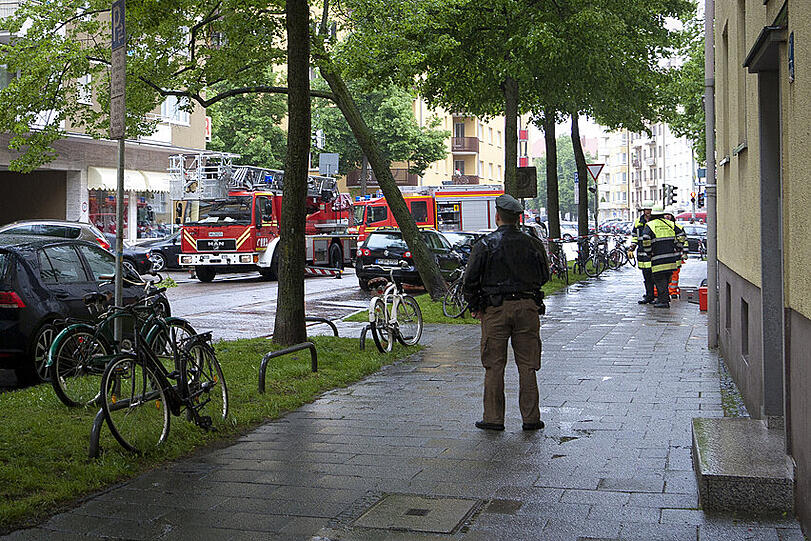 Polizisten sichern die Sperrzone, während die Feuerwehr den Baum in Augenschein nimmt und das Vorgehen abspricht.