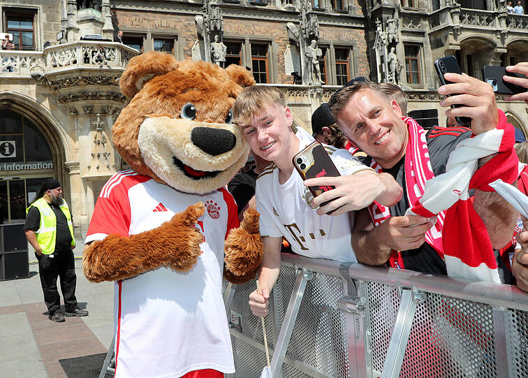 FC Bayern-Maskottchen Berni macht Selfies mit Fans auf dem Marienplatz.