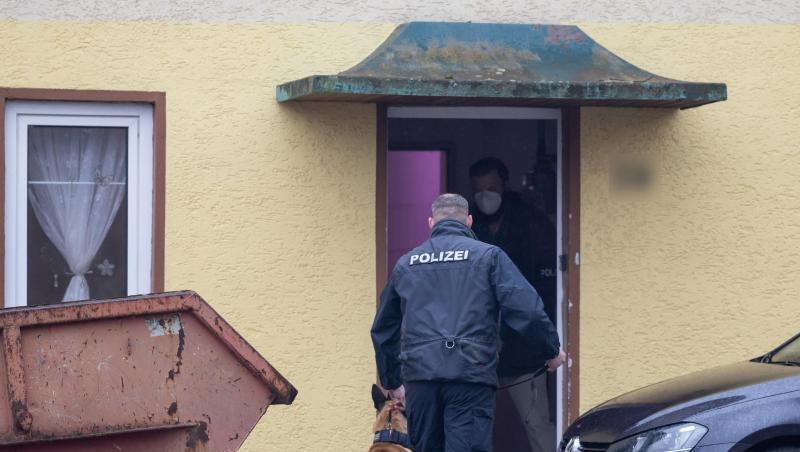 Ein Polizist geht mit einem Drogenspürhund in ein Haus im thüringischen Ballstädt.