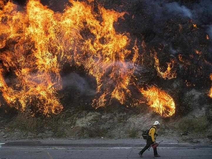 Ein Feuerwehrmann passiert im kalifornischen Newhall eine Wand aus Flammen.
