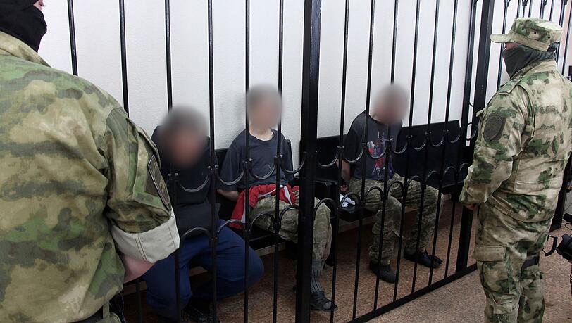 Schicksal ungewiss: Anfang Juni waren zwei britische Staatsbürger (links und rechts) und ein Marokkaner, die auf ukrainischer Seite gekämpft hatten, von einem Separatisten-Gericht in Donezk als Söldner zum Tode verurteilt worden. Schicksal ungewiss: Anfang Juni waren zwei britische Staatsbürger (links und rechts) und ein Marokkaner, die auf ukrainischer Seite gekämpft hatten, von einem Separatisten-Gericht in Donezk als Söldner zum Tode verurteilt worden.