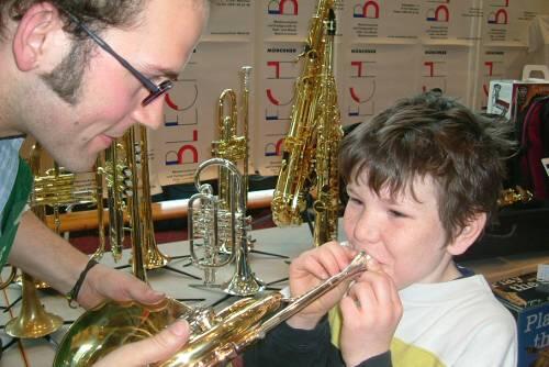 Große Tröte, kleiner Könner: Ein Bub beim Versuch, einem Horn Töne zu entlocken.