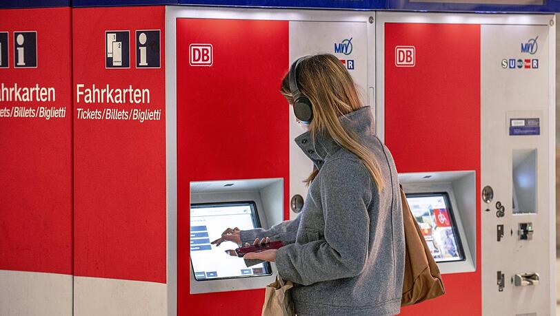 Eine Bahnkundin kauft in München an einem Fahrkartenautomaten ein Ticket - künftig soll das zu einem bundesweit einheitlichen Preis möglich sein. Doch einige Fragen sind offen.
