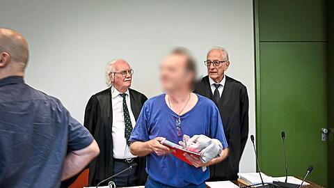 Mit Verspätung erscheint der Angeklagte Johannes M. im Gerichtssaal. Gleich zu Beginn hält er einen minutenlangen Monolog, in dem er unter anderem seine eigenen zwei Strafverteidiger (hinten) als " vermutlich pädokriminell" abstempelt.