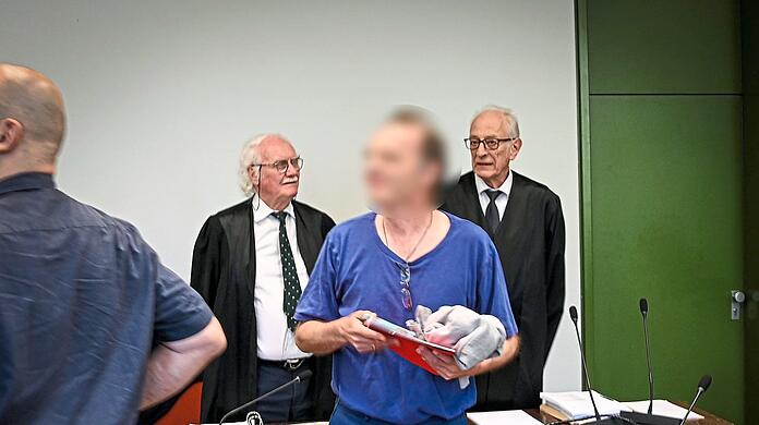Mit Verspätung erscheint der Angeklagte Johannes M. im Gerichtssaal. Gleich zu Beginn hält er einen minutenlangen Monolog, in dem er unter anderem seine eigenen zwei Strafverteidiger (hinten) als " vermutlich pädokriminell" abstempelt.