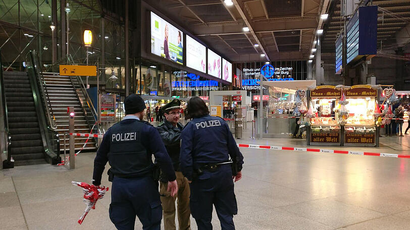 Ein Absperrband hängt in der Schalterhalle im Münchner Hauptbahnhof. Die Polizei hat den Bereich am Samstagabend evakuiert.