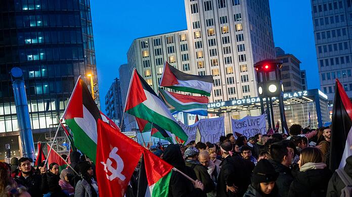 Teilnehmer einer pro-Palästina Demonstration stehen auf dem Potsdamer Platz in Berlin.