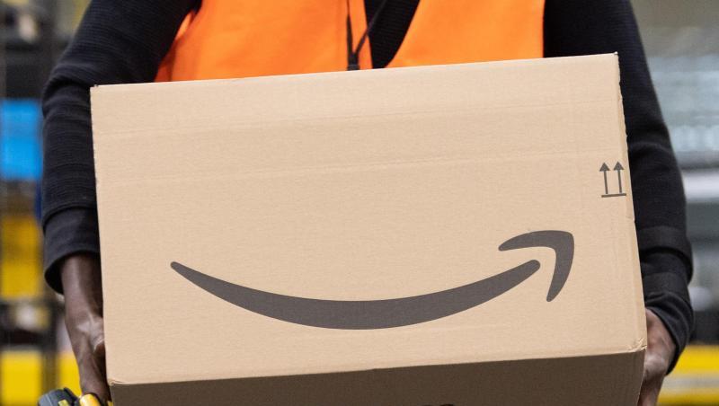 Ein Sortiermitarbeiter von Amazon trägt in einem Verteilzentrum ein Paket. Verbraucherschützer sehen die zunehmende Marktmacht großer Online-Plattformen wie Amazon mit Sorge. Ein Sortiermitarbeiter von Amazon trägt in einem Verteilzentrum ein Paket. Verbraucherschützer sehen die zunehmende Marktmacht großer Online-Plattformen wie Amazon mit Sorge.