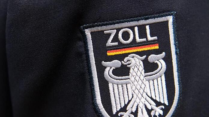 Das Logo der deutschen Zollbehörde ist an einer Uniform zu sehen.