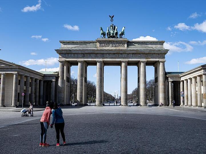 Zwei Joggerinnen machen auf dem sonst gut besuchten Pariser Platz vor dem Brandenburger Tor in Berlin ein Selfie.