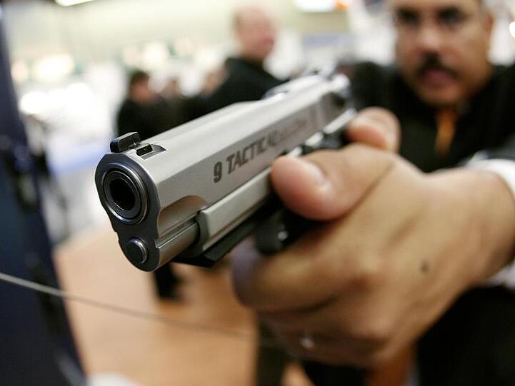 Ein Mitarbeiter des US-amerikanischen Herstellers Smith & Wesson auf der Waffenmesse in Nürnberg. Foto: Daniel Karmann / picture alliance / dpa