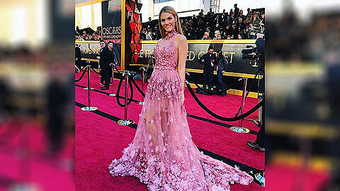 Viviane Geppert trug bei den Oscars ein rosafarbenes Kleid von Irene Luft mit aufgesetzten Blüten, einem durchsichtigen Rock und einer langen Schleppe.