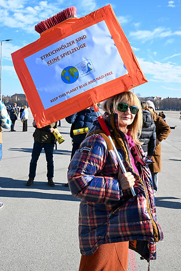 Demonstrantin mit selbstgebasteltem Schild.
