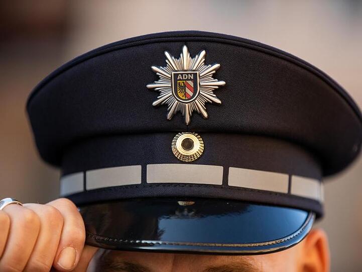 EIn Polizist mit Polizeimütze. Foto: Daniel Karmann/dpa/Archivbild