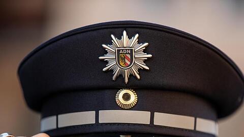 EIn Polizist mit Polizeimütze. Foto: Daniel Karmann/dpa/Archivbild