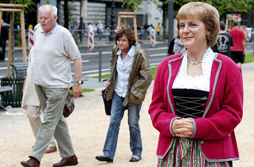 Nein, das ist nicht die echte Bundeskanzlerin. Eine Wachsfigur von Angela Merkel (CDU) mit Tracht in Berlin.