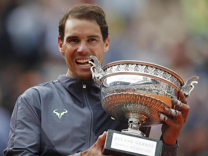 Rafael Nadal beißt nach seinem Sieg in die Trophäe.