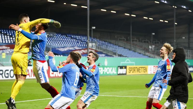 Kiels Torwart Ioannis Gelios (l) und seine Mitspieler feiern ihren Sieg mit 7:6 nach Elfmeterschießen. Kiels Torwart Ioannis Gelios (l) und seine Mitspieler feiern ihren Sieg mit 7:6 nach Elfmeterschießen.