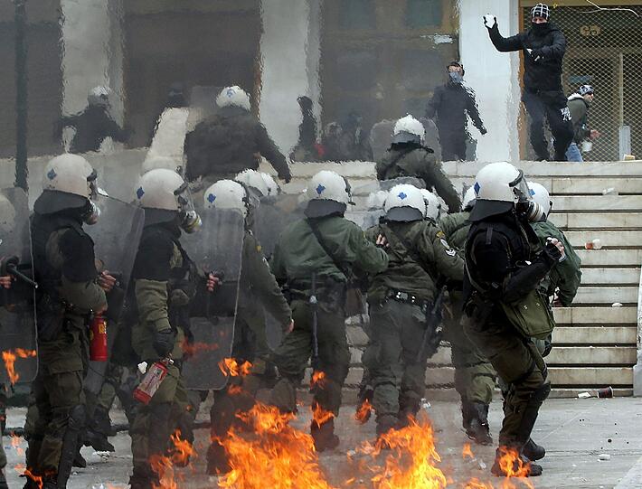 Brennende Geschäfte und Dutzende Verletzte: Stundenlange Krawalle begleiten in Athen die entscheidende Parlamentsdebatte. Immer wieder kam es jüngst zu Ausschreitungen. Die Bilder der vergangenen Tage aus Athen.