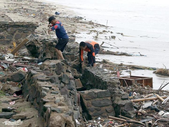 Rettungskräfte suchen am Strand von Carita nach Opfern des Tsunami.