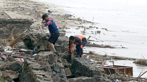 Rettungskräfte suchen am Strand von Carita nach Opfern des Tsunami.