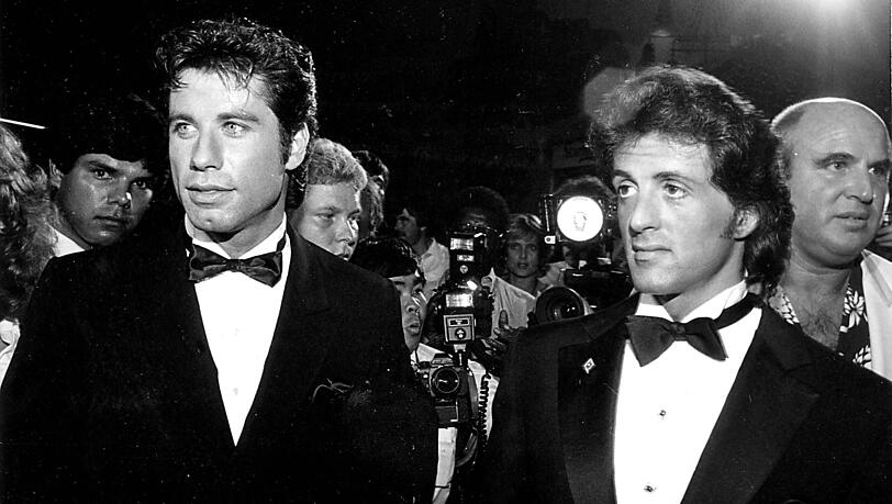 John Travolta (Hauptdarsteller) und Sylvester Stallone (Regisseur) bei der Filmpremiere von "Staying Alive" im Juli 1983. John Travolta (Hauptdarsteller) und Sylvester Stallone (Regisseur) bei der Filmpremiere von "Staying Alive" im Juli 1983.