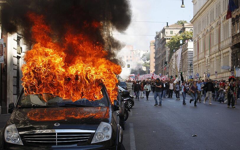 Brennende Autos, aufgebrachte Demonstranten, zerstörte Schaufensterscheiben: In Rom eskalierten die Proteste gegen die Bankenmacht und staatliche Sparkurse. Die Bilder von den Ausschreitungen.