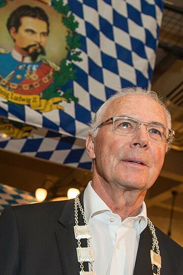 "Kaiser" Franz Beckenbauer steht am 27.03.2014 im Fürstlichen Brauhaus Thurn und Taxis in Regensburg mit der Salvator-Traditionskette vor einer Fahne mit einer Abbildung von König Ludwig II.
