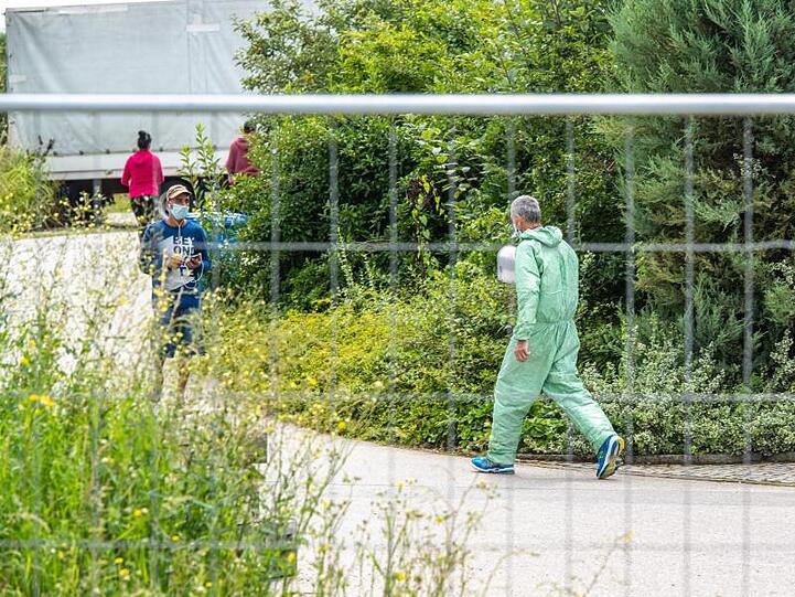 Ein Mann in Schutzanzug auf dem Gelände des Gemüsehofs in Mamming. Foto: Armin Weigel/dpa