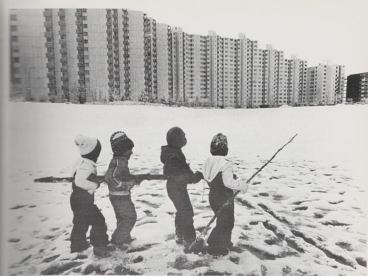 Neuperlach in den Anfangsjahren: Kinder spielen im Schnee vor der neuen, noch etwas trist wirkenden Hochhaus-Kulisse.