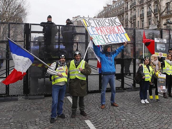 Demonstranten der "Gelbwesten"-Bewegung vor einer Straßensperre der Polizei in Paris. Francois Mori/AP