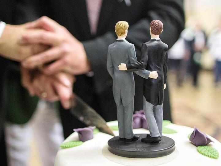 Ehe für Alle: Zwei Männer schneiden nach ihrer Eheschließung eine Hochzeitstorte an.
