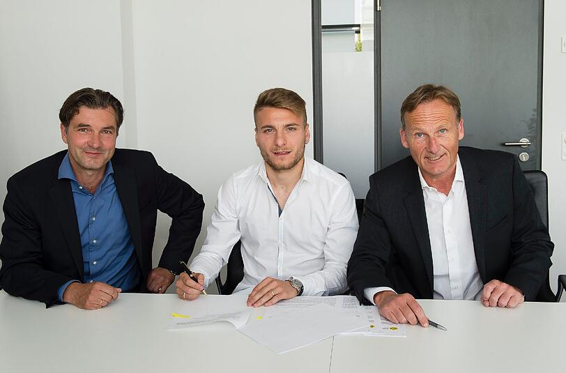 Ciro Immobile (M) bei der Vertragsunterzeichnung mit BVB-Sportdirektor Michael Zorc (L) und Geschäftsführer Hans-Joachim Watzke in Dortmund.