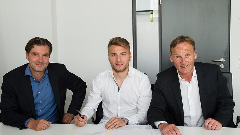 Ciro Immobile (M) bei der Vertragsunterzeichnung mit BVB-Sportdirektor Michael Zorc (L) und Geschäftsführer Hans-Joachim Watzke in Dortmund. Ciro Immobile (M) bei der Vertragsunterzeichnung mit BVB-Sportdirektor Michael Zorc (L) und Geschäftsführer Hans-Joachim Watzke in Dortmund.