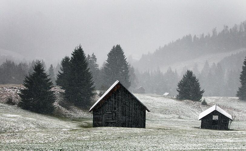 Schneebedeckte Hütten bei Oberjoch. Der stürmische Wind hat neben kalter Luft auch Schnee nach Bayern gebracht - zumindest in höheren Lagen.