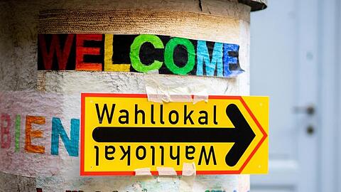 Ein Schild weist im Berliner Stadtteil Prenzlauer Berg den Weg zu einem Wahllokal.